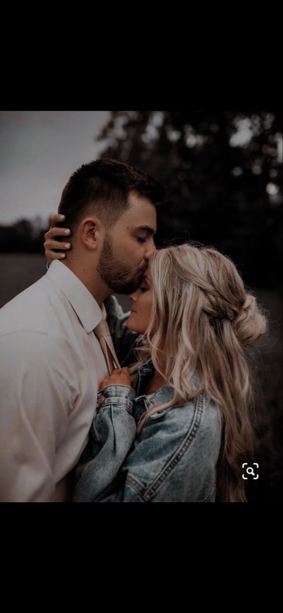 a man and woman kissing each other in the middle of an image with trees in the background