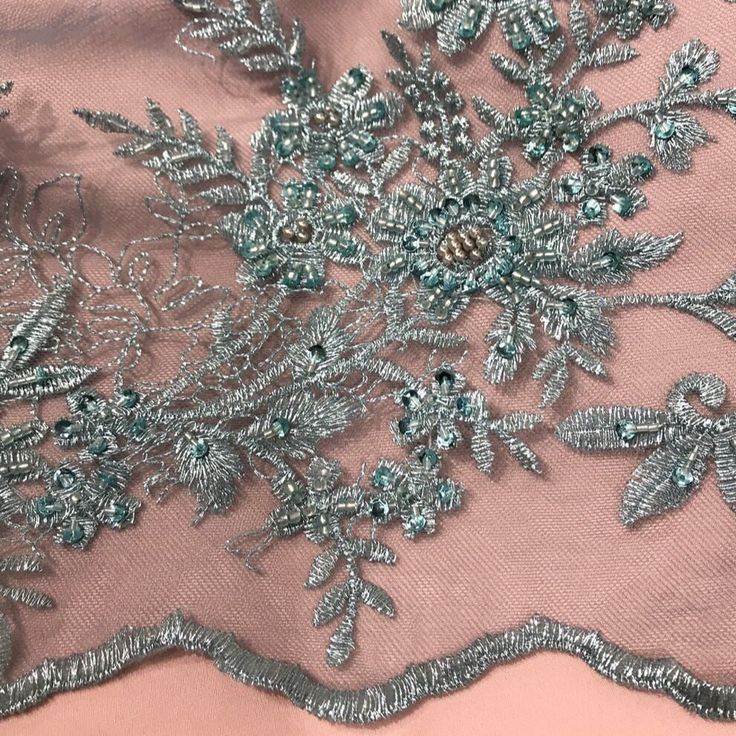 Introducing the exquisite Beaded Floral Lace Fabric Embroidered on 100% Polyester Net Mesh exclusively from Lace USA. This gorgeous couture lace is perfect to create a breathtaking dress for any special occasion. Whether it is a bridal look, quinceanera dress, evening dress, dance costume, or formal dress, this fabric will bring a touch of elegance, beauty and luxury to your look. The lace fabric features painstakingly hand embroidered beads, sequins, and pearls against a 100% Polyester net mesh Lace Embroidered Fabric For Reception, Intricately Embroidered Fitted Fabric For Mother Of The Bride, Fitted Embroidered Fabric For Mother Of The Bride, Silver Embroidered Fabric With Floral Design, Silver Embroidered Lace For Party, Festive Fitted Lace With Intricate Embroidery, Fitted Lace With Intricate Embroidery For Festive Season, Silver Lace With Intricate Embroidery, Festive Embellished Lace Embroidered Fabric