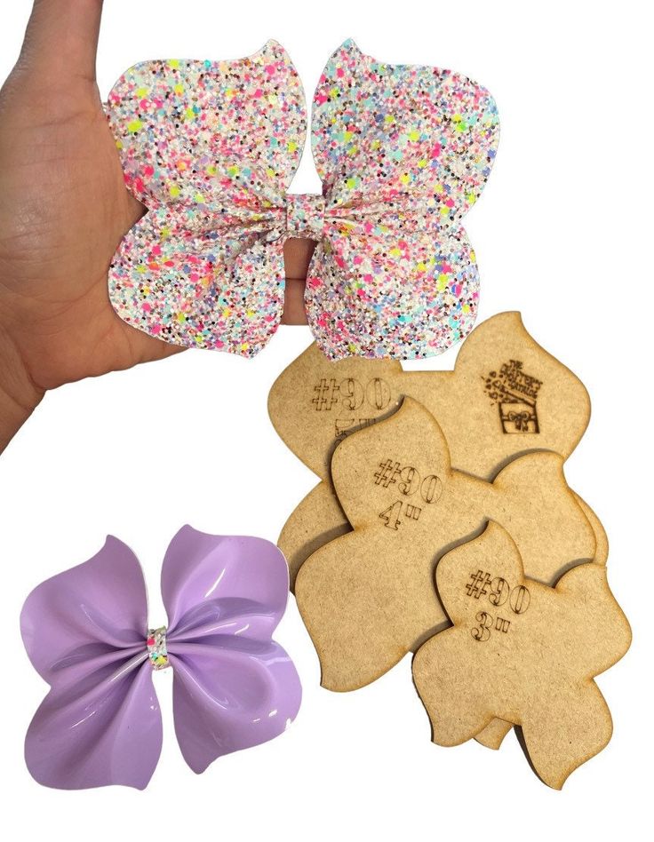 a hand is holding several bows and cookies