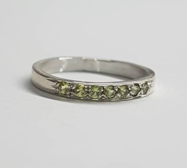 Handmade delicate half eternity stacking ring, stoned with 7 beautiful light green gemstones.  This multistone ring is beautiful alone or stacked together with other rings and is colorful and pretty on your finger.  The ring is available in nickel free, 14 karat gold plating over a brass or silver base. Can be also ordered in solid sterling silver, 9k or 14k solid gold.  A perfect beautiful gift for yourself or for a women you love. Dimensions: The ring width is about 2 mm. Multiple ring sizes a Green Peridot Stackable Promise Rings, Green Stackable Rings With Accent Stones For May Birthstone, Green Half Eternity Stackable Rings For Anniversary, Green Stackable Eternity Band For Promise, Green Half-eternity Stackable Rings For Anniversary, Green Gemstone Eternity Band For Promise, Stackable Peridot Rings For Anniversary, Stackable Peridot Promise Ring, Stackable Peridot Birthstone Ring For Anniversary