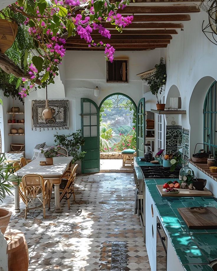 an open kitchen and dining area with potted plants on the ceiling, table and chairs