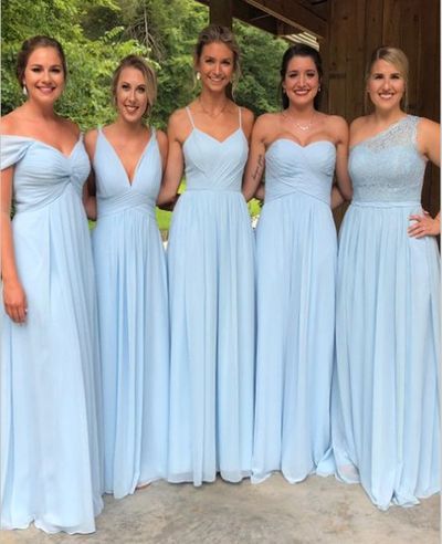 four bridesmaids pose for a photo in front of a covered area with trees