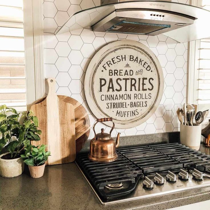 a stove top oven sitting inside of a kitchen next to a potted plant and wooden cutting board