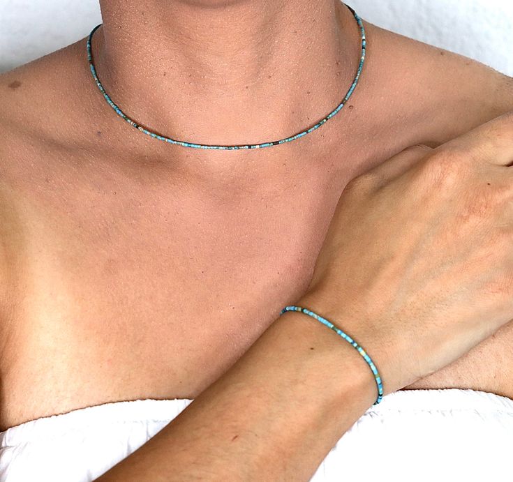 Celebrate December birthdays with our stunning collection of Bohemian chokers and necklaces, featuring genuine turquoise gemstones known for their healing properties. Our artisan handmade turquoise necklaces and bracelets are crafted with top-quality gemstones and meticulous attention to detail. These dainty chokers and minimalist necklaces, adorned with tiny 1 mm turquoise beads, are perfect for layering or wearing alone. Ideal for weddings, bridesmaids, or as a thoughtful gift for men and wome Adjustable Turquoise Choker With Tiny Beads, Adjustable Turquoise Beaded Choker, Adjustable Turquoise Dainty Choker, Bohemian Turquoise Choker With Tiny Beads, Dainty Turquoise Adjustable Choker, Dainty Turquoise Single Strand Jewelry, Blue Minimalist Choker Jewelry, Minimalist Blue Choker Jewelry, Handmade Minimalist Turquoise Jewelry