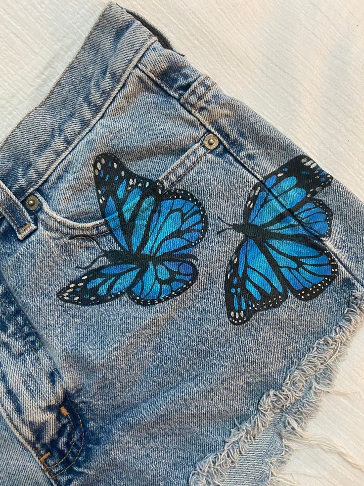 Short Pocket Painting, Jeans Painting Butterfly, Denim Short Painting Ideas, Fabric Painting Jeans, Fabric Paint Designs On Jeans, Denim Shorts Painting, Cute Fabric Painting, Cute Jeans With Designs, Painting Jean Shorts