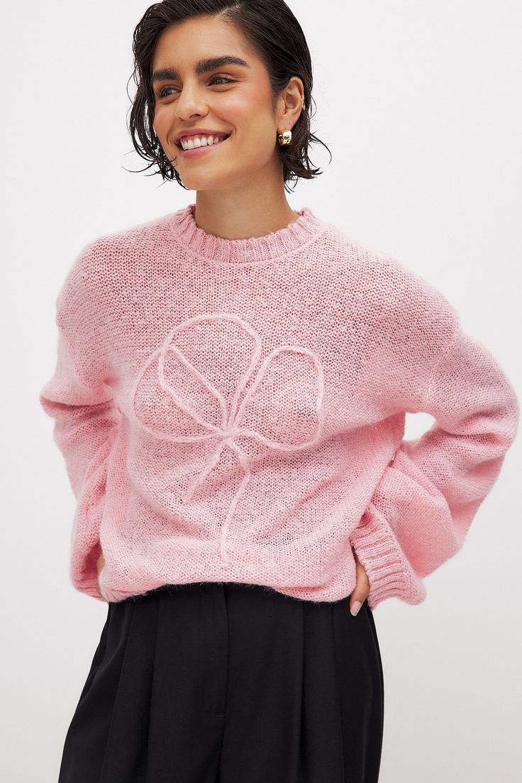 This sweater features an oversized fit and a stretchy, soft, loose knit material. It has a round neckline and ribbed hems. Cozy Pink Sweater With Ribbed Cuffs, Oversized Textured Knit Top With Crew Neck, Oversized Textured Knit Crew Neck Top, Trendy Pink Cropped Sweater With Ribbed Cuffs, Trendy Pink Cropped Knit Sweater, Pink Trendy Cropped Knit Sweater, Trendy Cropped Soft Knit Sweater With Crew Neck, Trendy Cropped Sweater With Crew Neck In Soft Knit, Trendy Crew Neck Cropped Sweater In Soft Knit