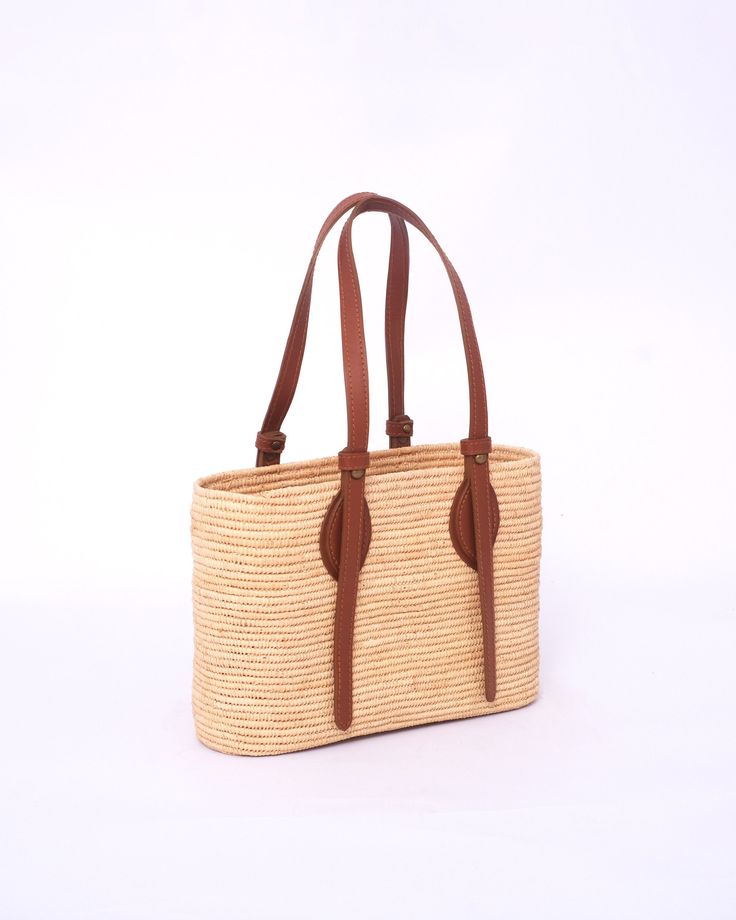 this stunning raffia handmade bag to our customers. This versatile bag can be used as both a shoulder bag and a handbag, making it the perfect accessory for any woman. The natural and eco-friendly raffia material used in this bag makes it a great choice for those who value sustainability. The bag comes in natural raffia color and black , so you can choose the one that best suits your personal style. Our skilled artisans have crafted this bag with traditional techniques and attention to detail, e Artisan Shoulder Bag With Braided Handles For Travel, Woven Leather Shoulder Bag For Vacation, Natural Fiber Straw Shoulder Bag With Adjustable Strap, Leather Woven Shoulder Bag For Vacation, Leather Shoulder Bag With Woven Detail For Vacation, Straw Shoulder Bag With Adjustable Strap, Handwoven Palm Leaf Beach Bag For Travel, Everyday Woven Leather Jute Shoulder Bag, Summer Shoulder Bag In Natural Fiber For Daily Use