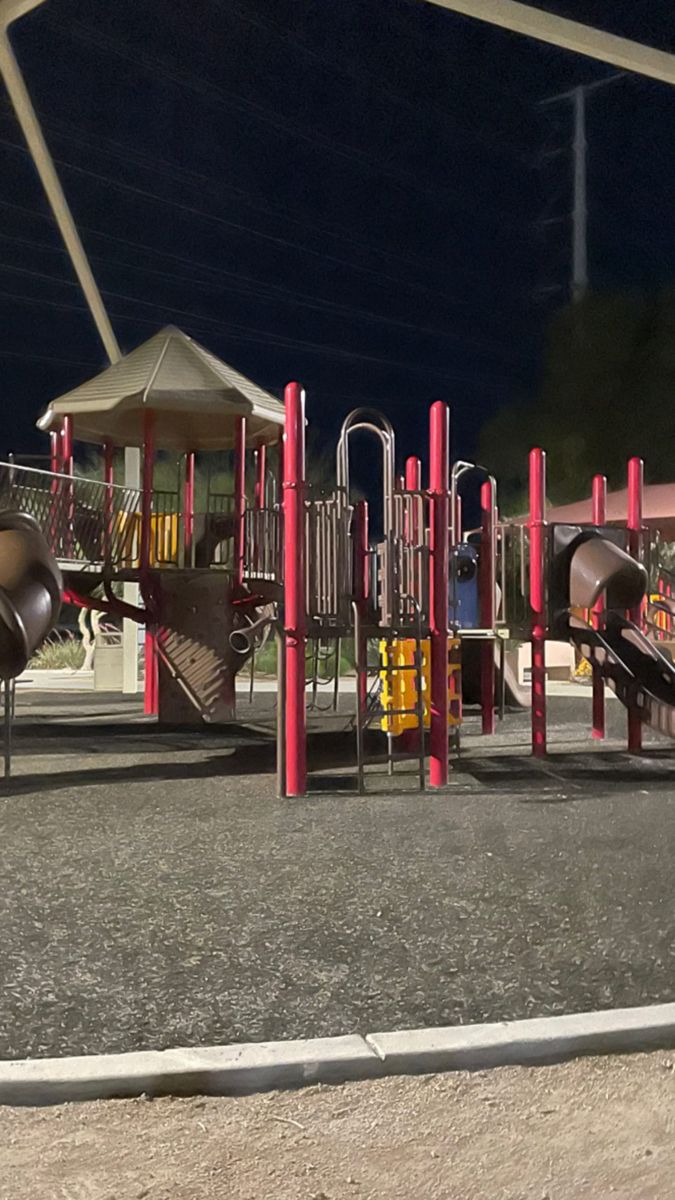 an empty playground at night with children's play equipment