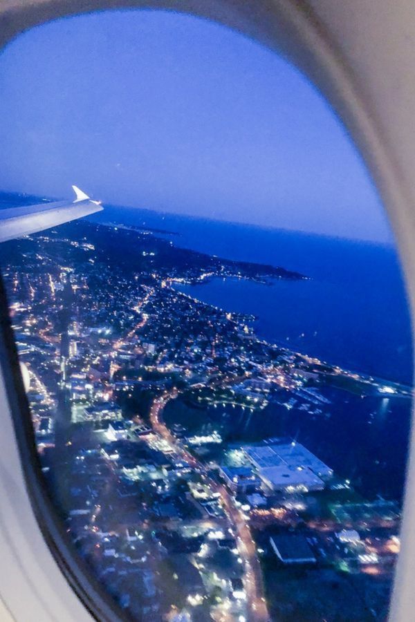 an airplane window looking out at the city lights