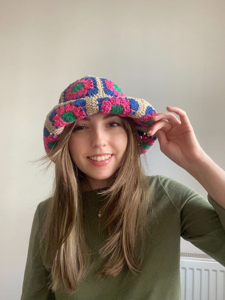 a young woman wearing a colorful crocheted hat