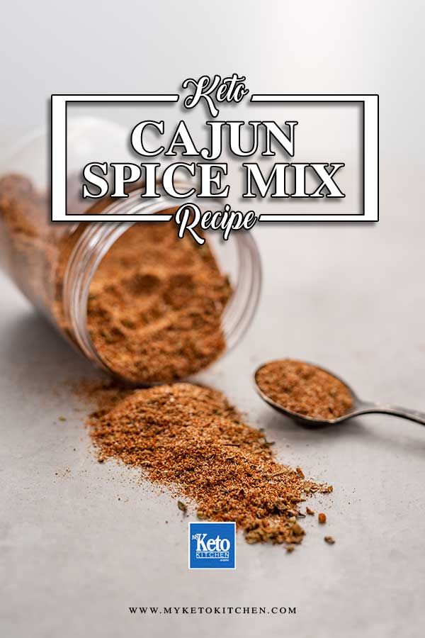 a spoon full of spices next to a jar with the words keto cajun spice mix