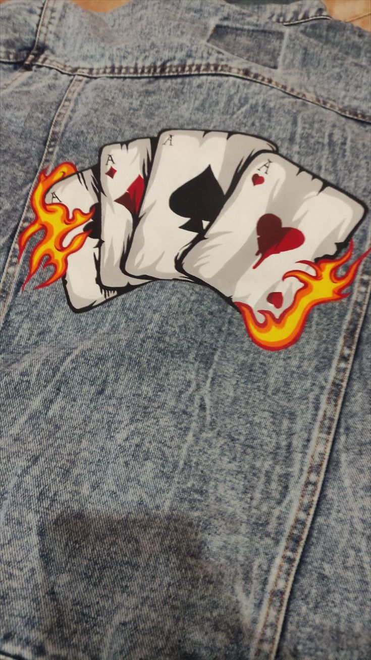 Add some personality to your style with this custom denim jacket. The playing card design is hand-painted with high-quality acrylic paint, ensuring that your jacket will be one of a kind.#Swagart #Swagartstyle #Swagartstylecartoon #Stylecartoon  #Artstylecartoon Denim Pants Painting Ideas, Denim Jacket Design Ideas Paint, Acrylic Paint On Jeans, Men Jeans Painting Ideas, Painting On Pants Ideas, Denim Painting Ideas, Painting Denim Jacket, Denim Jacket Painting For Men, Denim Jacket Art Anime