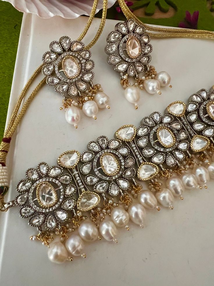 One of our favorite picks for the wedding season ♥️ The gorgeous choker is beautifully handcrafted by our skilled Indian craftsmen in Kundan stones, Ghungroo, mini pearls, and dual tone plated. The beautiful Kundan earrings add to the traditional ethnicity of the piece. Material: Brass with dual tone plating The length of the earrings is 5 cm. The width of the earrings is 3 cm. The weight of the earrings is 28 grams per pair. Silver Dual-tone Kundan Necklace For Wedding, Elegant Dual-tone Kundan Bridal Necklace, Elegant Kundan Dual-tone Bridal Necklace, Wedding Silver Dual-tone Kundan Necklace, Dual-tone Jewelry Sets For Wedding, Silver Kundan Choker As Gift, Silver Kundan Choker For Gift, Elegant Dual-tone Kundan Necklace For Wedding, Fusion Style Silver Choker For Weddings