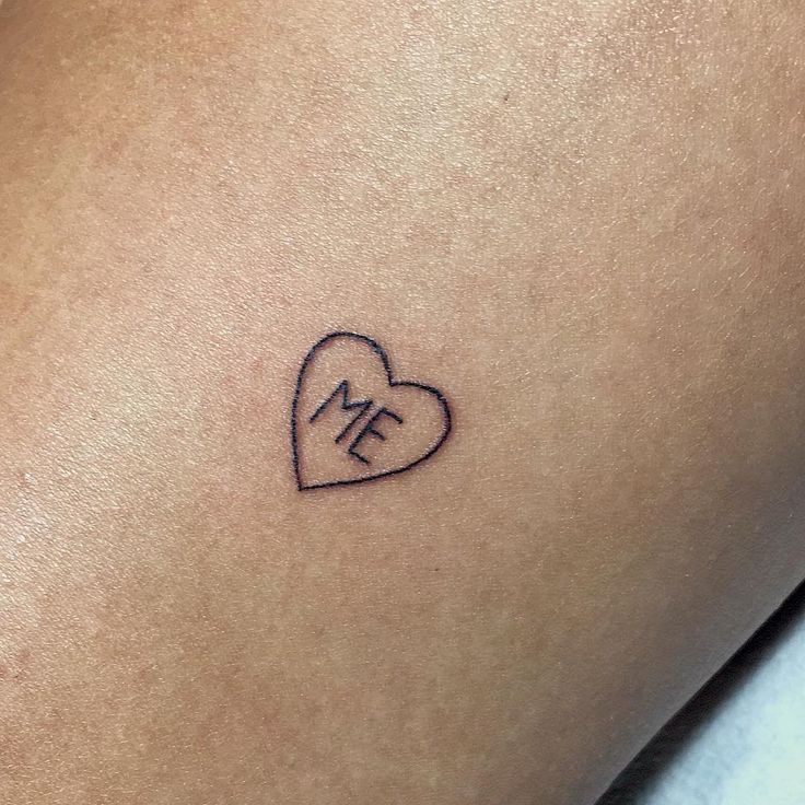 a small heart tattoo with the letter e on it's side ribcage