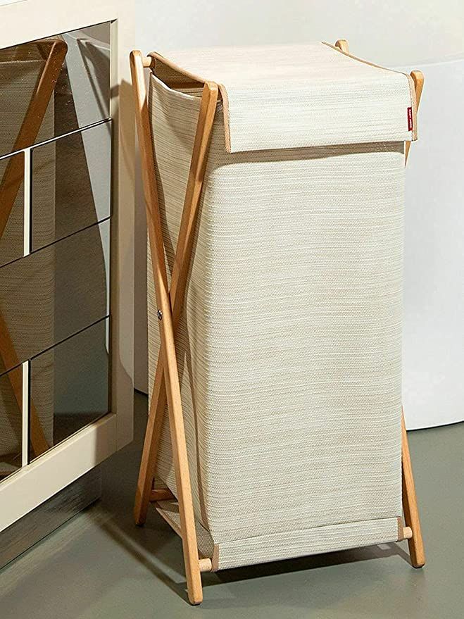 a white cabinet sitting next to a mirror on top of a table with a towel rack in front of it