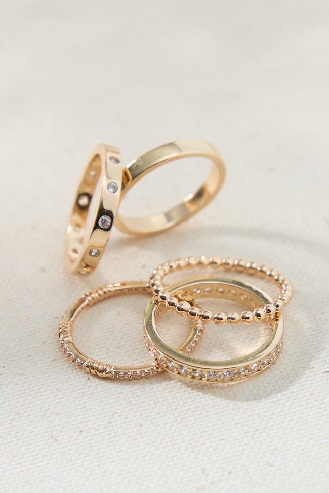 The set offers a variety of rings, allowing you to mix and match, stack them together, or wear them individually. The classic gold band design ensures a timeless look that transcends trends. However, the sparkling crystals add a touch of modern flair, keeping the rings relevant and stylish for any occasion. Gold Rings Set, Simple Gold Band, Rings Stack, Xmas Wishlist, Rings Aesthetic, Nail Ring, Band Design, Beaded Jewelry Designs, Ring Stack