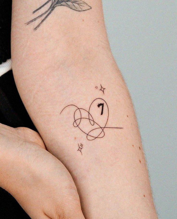 a woman's arm with a tattoo on it and the number one in the middle