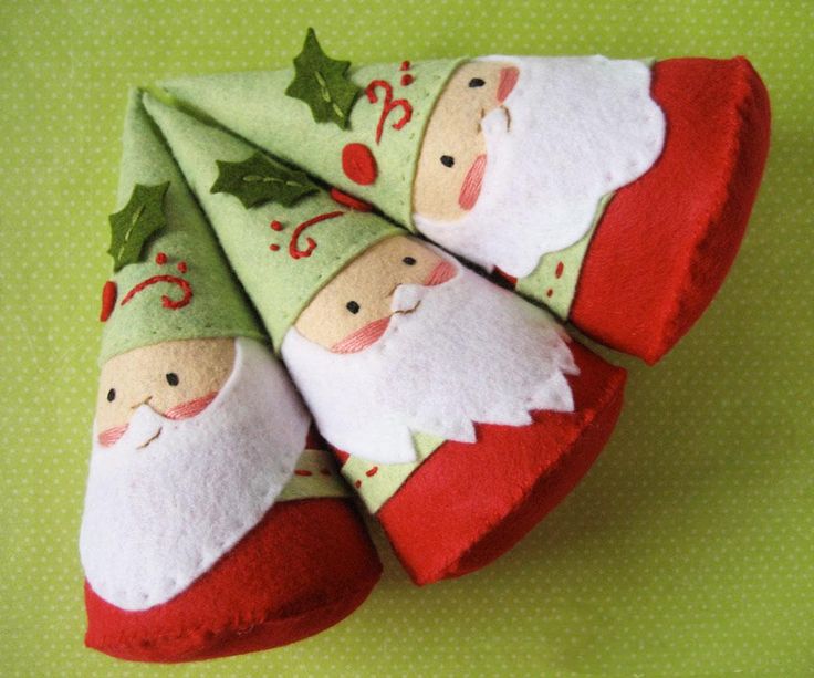 three felt christmas stockings with santa claus on them