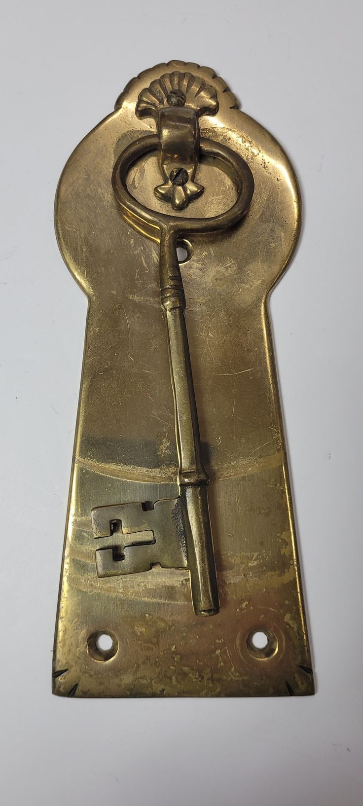 an antique brass keyhole on a white background