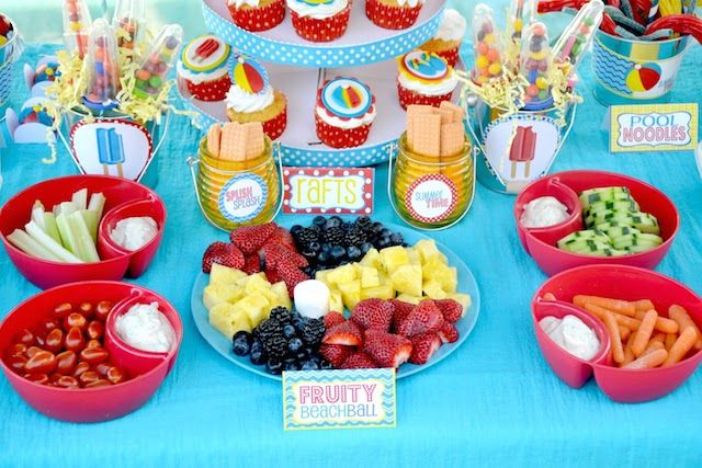 a table topped with lots of fruit and cupcakes