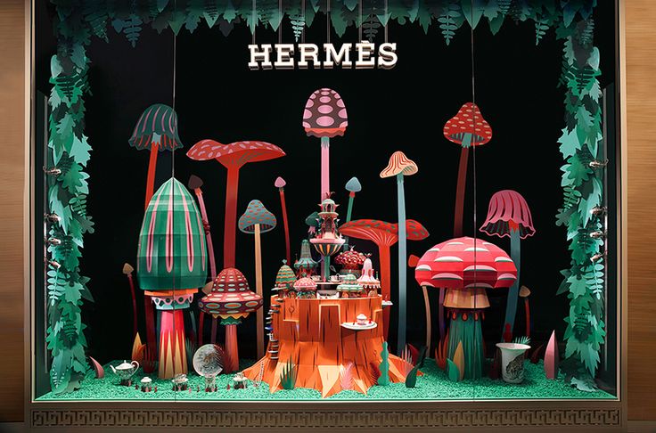 an assortment of colorful mushrooms and plants on display in a store window with the words hermes above them