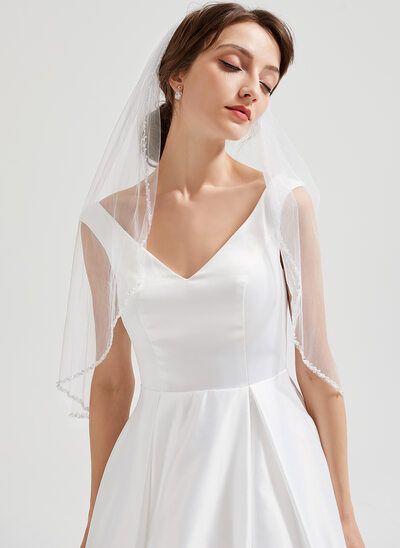 a woman wearing a white wedding dress and veil