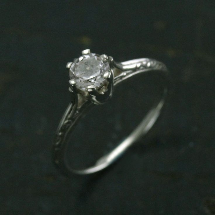 a white diamond ring sitting on top of a table