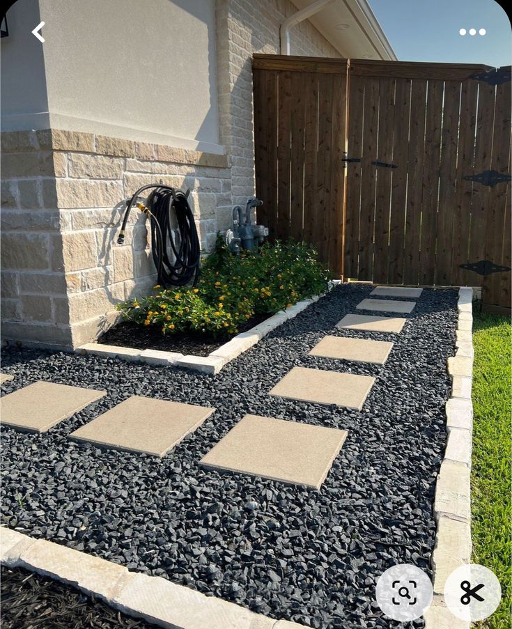 a small garden with gravel and rocks in the front yard