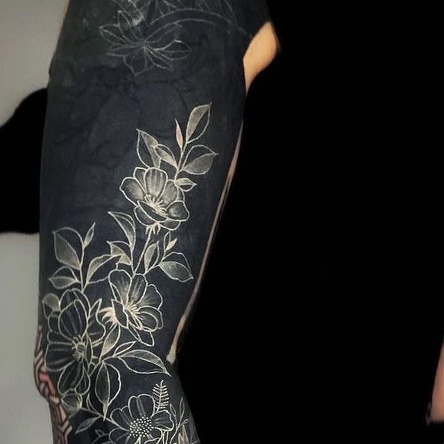 a woman with black and white tattoos on her arm