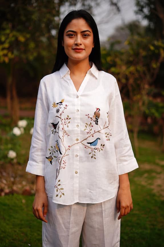 White linen shirt with multi colored bird pattern embroidery. - Aza Fashions Traditional Collared Tops With Floral Embroidery, Embroidered Cotton Collared Tops, Summer Cotton Tops With Bird Print, Relaxed Fit Tops With Floral Embroidery And Spread Collar, Summer Floral Embroidered Top With Spread Collar, Summer Top With Floral Embroidery And Spread Collar, Spring Embroidered Tops With Spread Collar, Spring Embroidered Spread Collar Tops, Casual Floral Embroidery Tops With Spread Collar