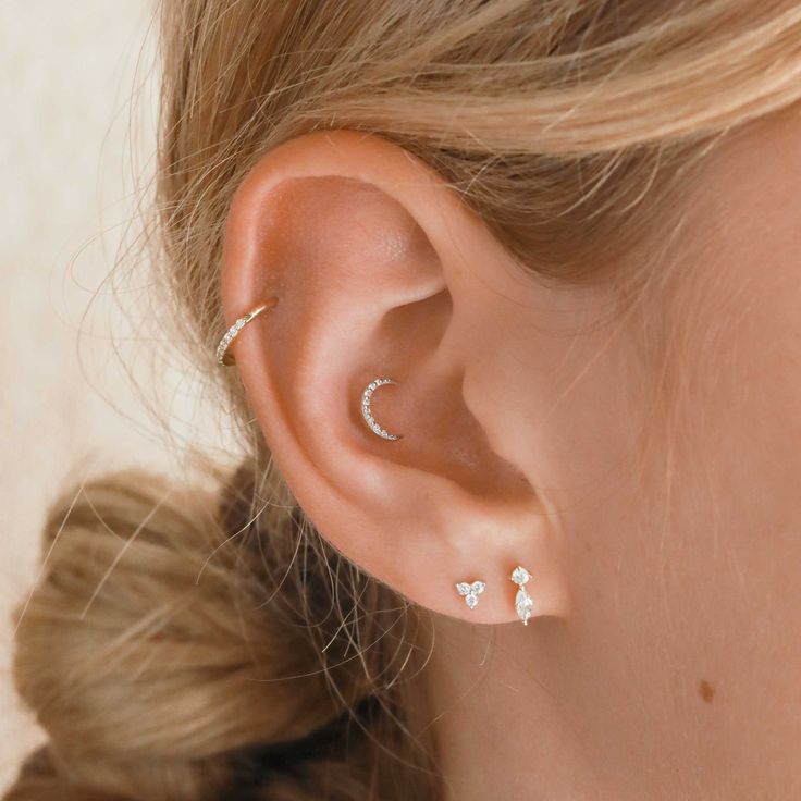 a close up of a person's ear with two piercings