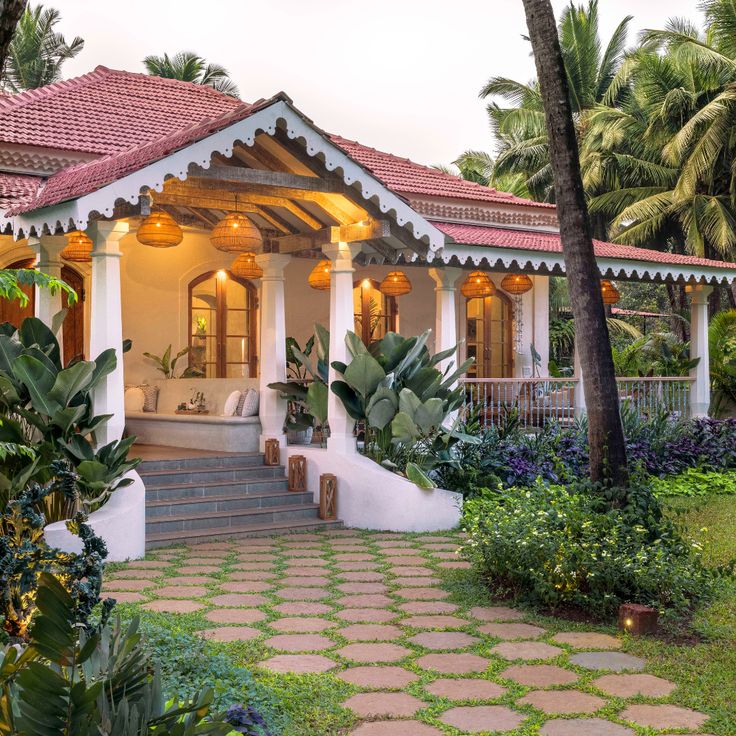 a white house surrounded by palm trees and greenery