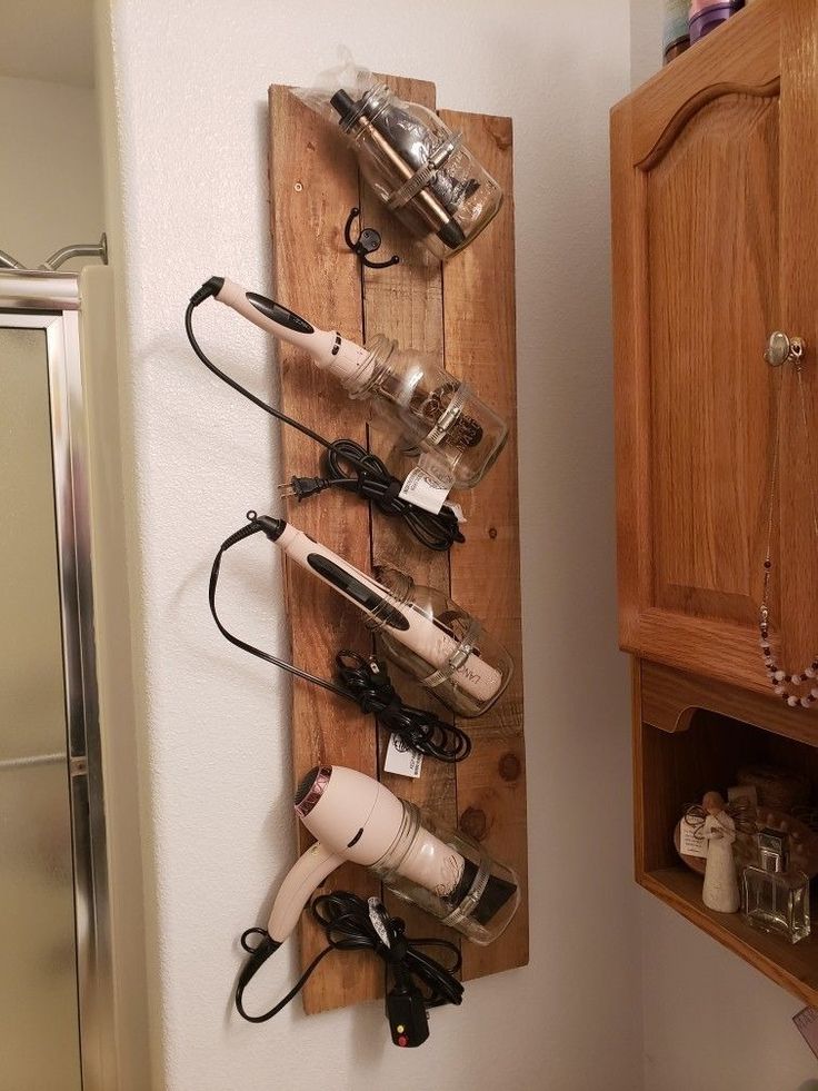 a wooden rack with hair dryers and other items hanging on it's sides