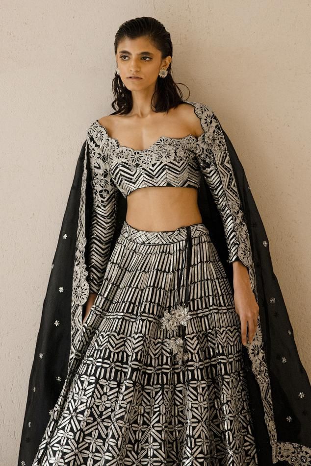 Black lehenga featuring all-over metallic tape and sequin embroidery. Paired with a matching blouse with long sleeves and a floral embroidered border dupatta., Fit: Relaxed Party Lehenga With Motifs For Navratri, Navratri Party Lehenga With Motifs, Festive Party Lehenga With Motifs, Floor-length Party Choli With Motifs, Party Floor-length Choli With Motifs, Festive Party Sets With Motifs, Bollywood Wedding Palazzo Set With Motifs, Bollywood Party Sets With Motifs, Floor-length Lehenga With Motifs For Party