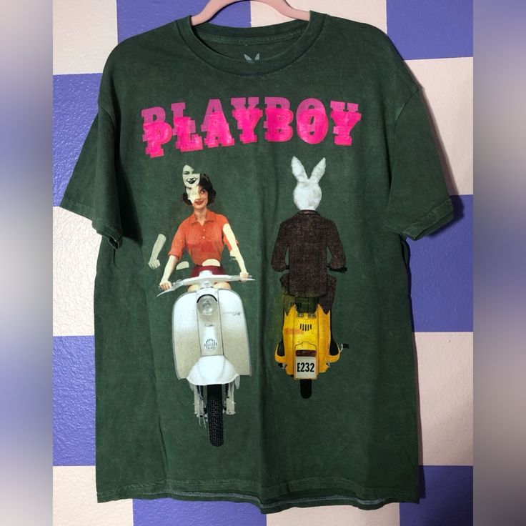 New Without Tags Officially Licensed Shirt On Quality Green Shirt With Distressed Coloring And Contrast Stitching. I Believe It’s Mid Weight Graphic Is Of The Playboy June 1959 Cover Of A Bunny And Woman Passing Each Other On Motorbikes. This Shirt Is A Misprint - The Graphic Was Printed On Front And Back, And On The Front Was Double/Triple Printed Creating A Ghostly Duplicative Effect. There Are Also Touches Of Color Across The Shirt From The Misprint (A Little Red On The Shoulder, Little White Vintage Urban Outfitters T-shirt For Summer, 90s Style Green T-shirt For Spring, Retro Cotton Tops By Urban Outfitters, Retro Cotton Tops From Urban Outfitters, Spring Retro Pre-shrunk Shirt, Urban Outfitters Retro Graphic T-shirt, Urban Outfitters Retro Graphic Print T-shirt, Urban Outfitters Letter Print T-shirt For Spring, Urban Outfitters Graphic Print Cotton Tops