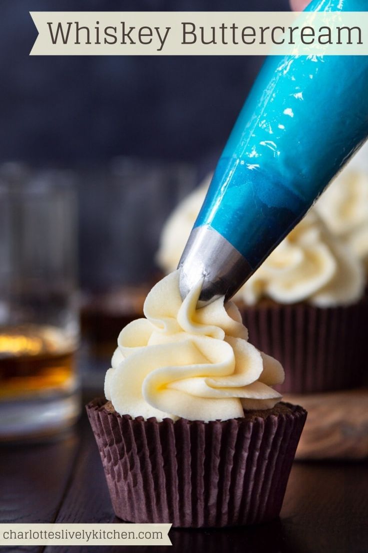 a cupcake being frosted with white icing and a blue marker on top