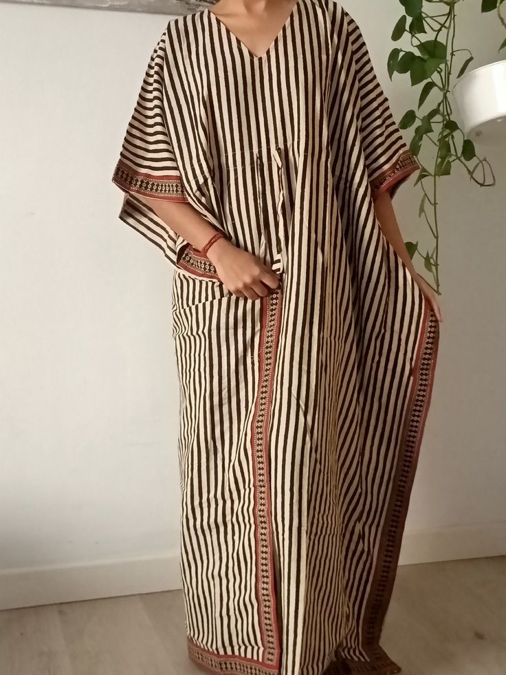 This Item is handmade. We use organic top quality cotton to ensure your skin is pampered and always natural. It is beautifully painted on with blocks- a traditional Indian style of printing.Each layered block by block,colour by colour, creating an exquisite design. The dyes used are also organic. The design is multi functional depending on your mood, Use it like a kaftan to lounge around the house in or even as a swim cover up for your day at the beach or pool. The second item and consecutive it Striped Cotton Maxi Dress For Vacation, Bohemian Striped Maxi Dress For Beach, Bohemian Striped Maxi Dress For Beach Cover-up, Bohemian Striped Tunic Dress, Traditional Thobe With Kimono Sleeves For Beach, Brown Long Kaftan For Beach Cover-up, Bohemian Striped Kaftan For Summer, Brown Tunic Kaftan For Beach, Brown Long Kaftan For Vacation