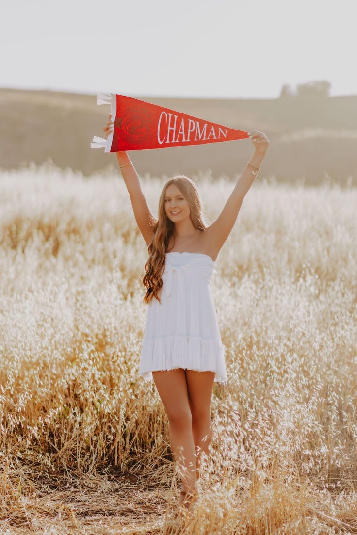 a woman in a white dress is holding up a red sign that says chaman