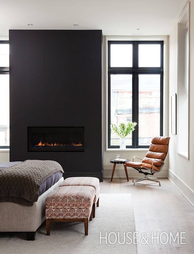 a bedroom with a bed, chair and fire place in the wall above it's fireplace