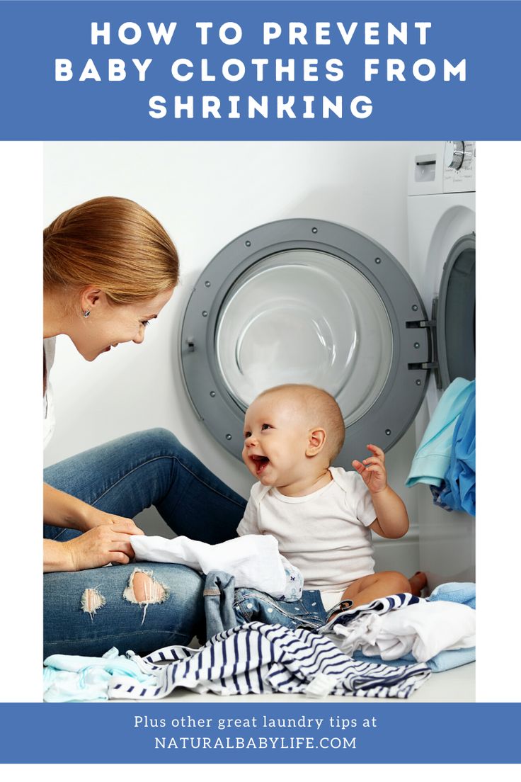 a woman and baby sitting on the floor next to a dryer with clothes in it