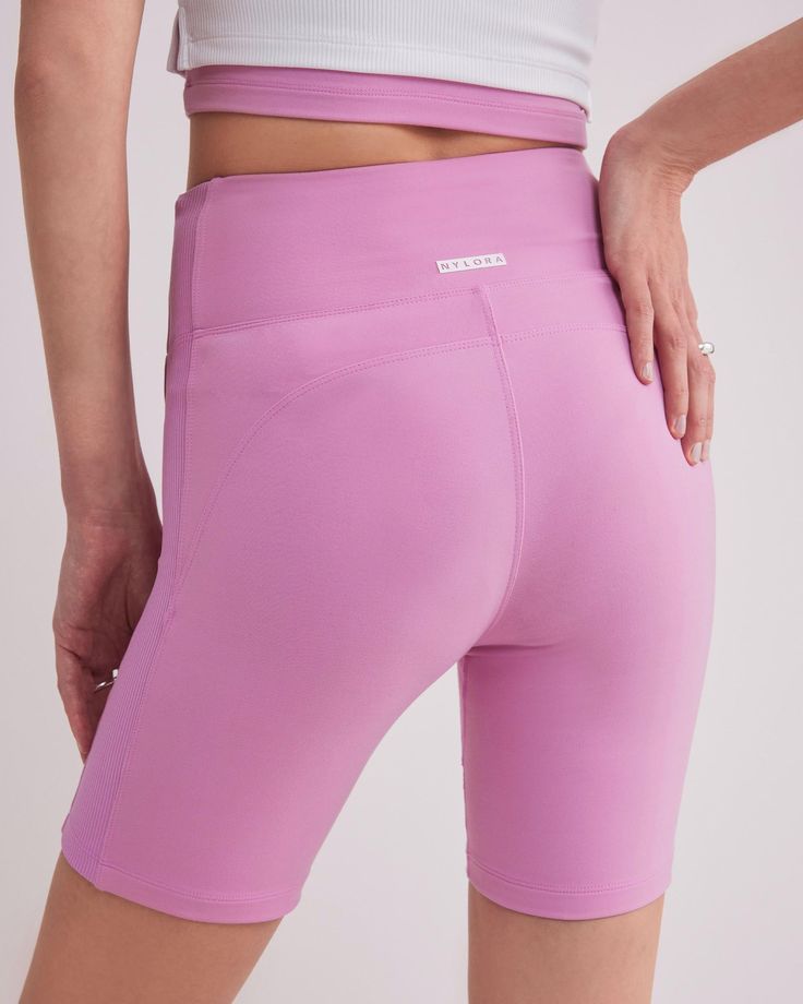 DETAILS: Color: Bubble gum pink High waist biker shorts with side contrast fabric Super soft & delicate brushed body fabric Medium weight 2x2 ribbed fabric on side panel Rubberized brand logo detail at back waist Body: 77% Nylon, 23% Spandex Contrast fabric: 93% Polyester, 7% Spandex Machine wash SIZE & FIT: Fits true to size Waist: 10 3/4" Inseam: 7" Model is wearing a size S Sporty Biker Shorts With Ribbed Waistband, Pink Short Bottoms For Athleisure, Pink High Waist Athletic Shorts With Built-in Shorts, Pink Activewear With Built-in Shorts For Yoga, Fitted Pink Activewear With Built-in Shorts, Sporty Stretch Biker Shorts With Ribbed Waistband, Fitted Biker Shorts With Ribbed Waistband For Workout, Fitted Biker Shorts With Ribbed Waistband, High Stretch Pink Athleisure Shorts