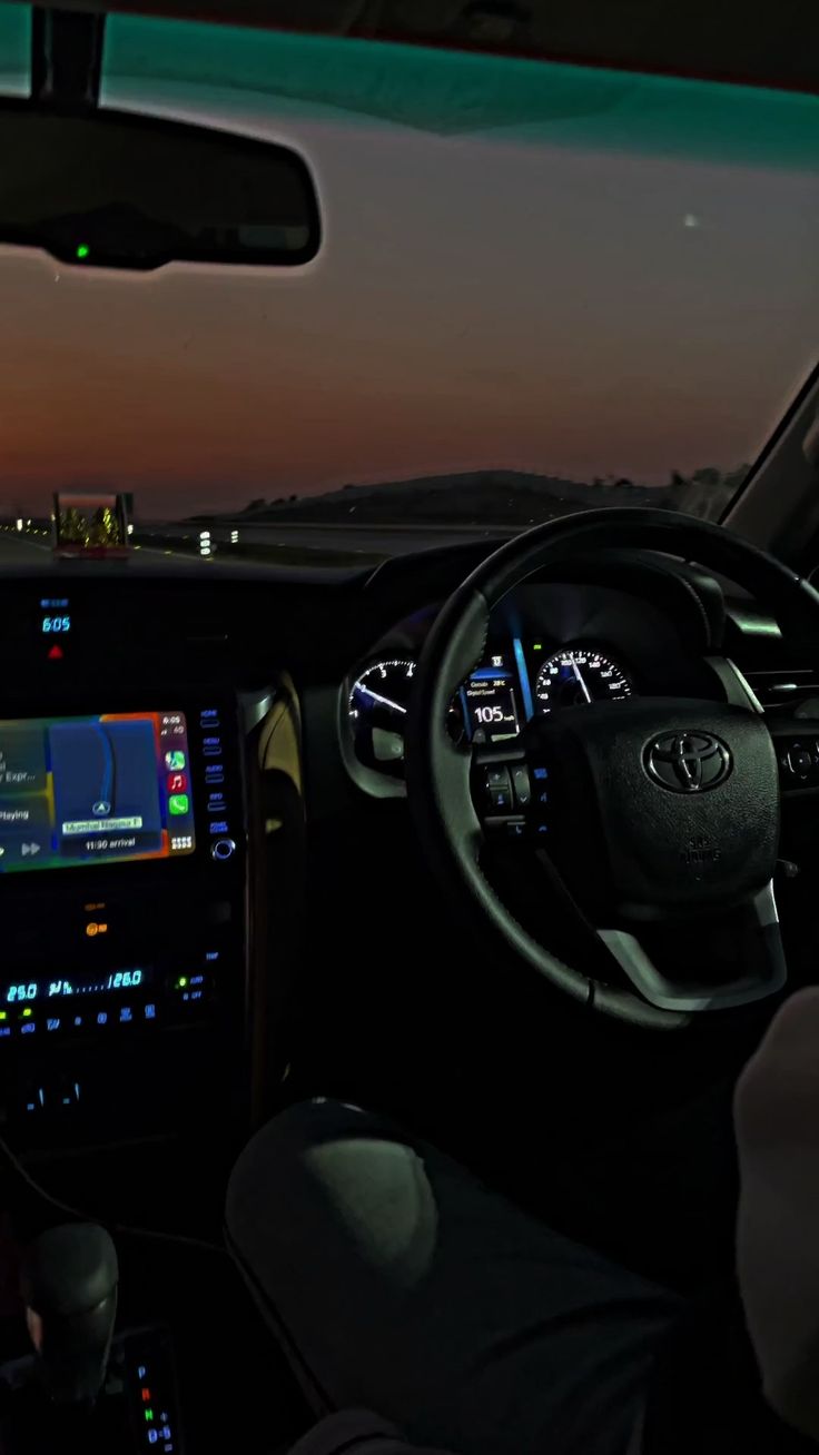 the interior of a car with its dashboard illuminated at night