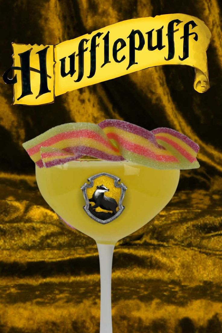 a glass filled with liquid sitting on top of a table next to a yellow banner