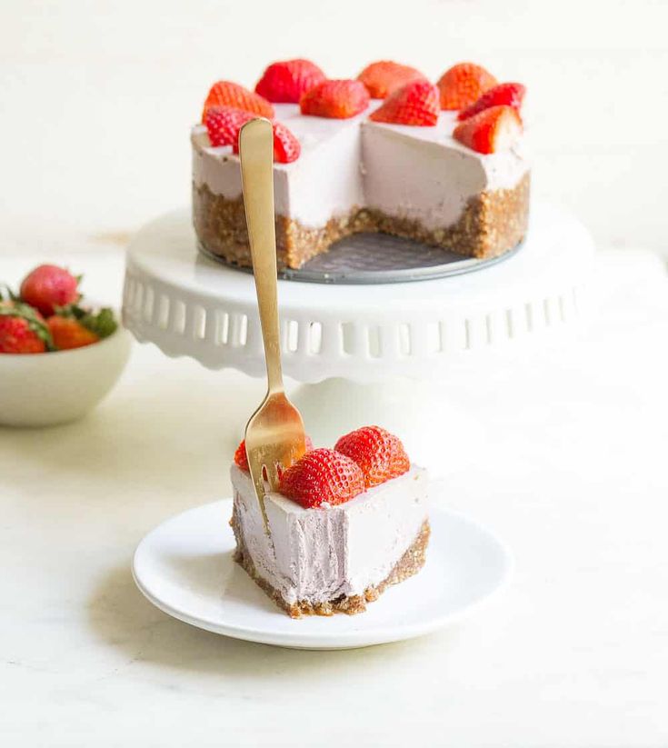 a slice of cheesecake with strawberries on top and a fork in the middle