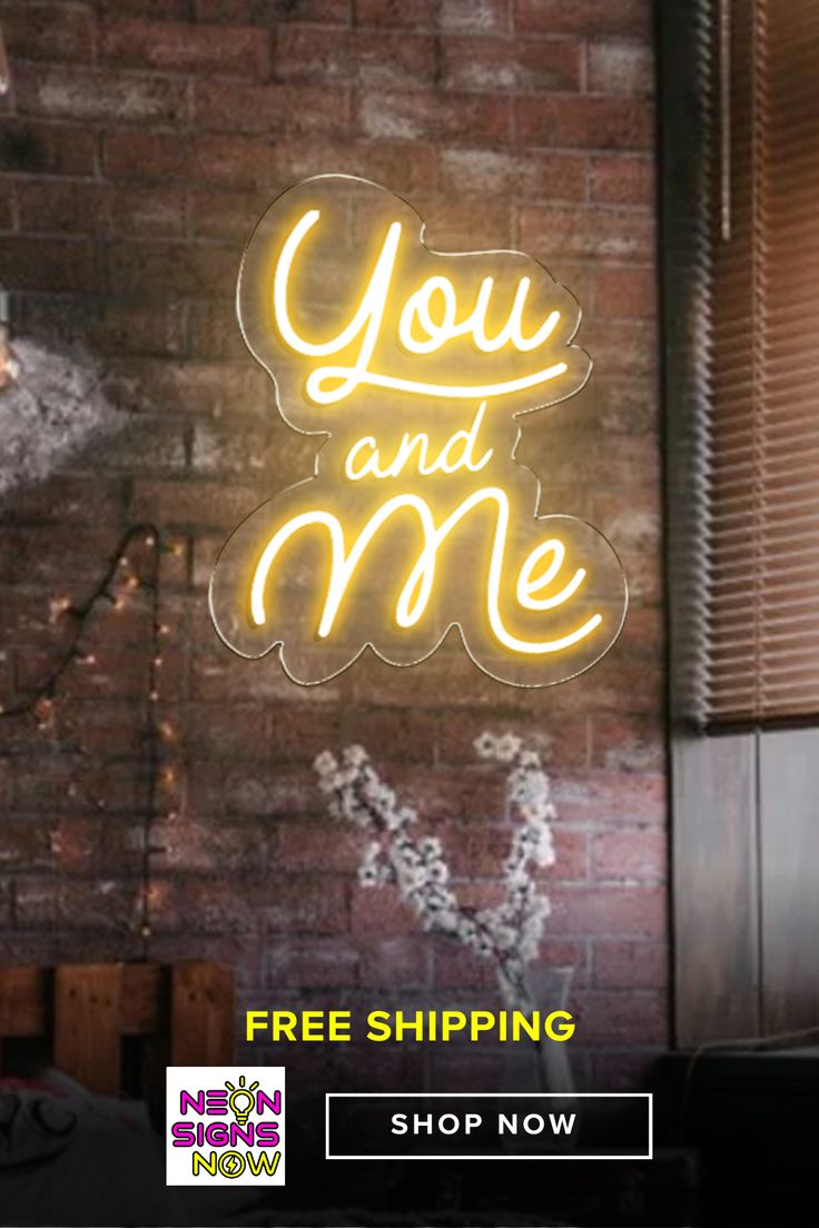 a neon sign that says you and me on the side of a brick wall next to a window