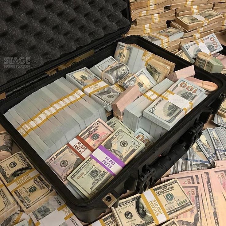 a suitcase filled with money sitting on top of a pile of cash