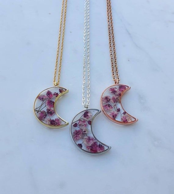 This listing is for real gypsophila or baby's breath buds handpicked and pressed and set in resin inside a crescent moon shaped gold, silver or rose gold effect bezel pendant on either a 24" 18ct gold plated steel chain, a 20" 18ct rose gold plated chain or a 24" silver plated chain.These are all unique and would make the perfect gift for someone special. Delicate Crescent Rose Gold Jewelry, Handmade Rose Gold Necklace For Mom, Handmade Rose Gold Necklaces For Mother's Day, Rose Gold Crescent Necklace Gift, Handmade Rose Gold Necklace Gift For Mom, Rose Gold Crescent Jewelry Gift, Handmade Rose Gold Jewelry For Bridesmaids, Pink Flower Pendant Jewelry With Pressed Flowers, Pink Pressed Flowers Jewelry With Flower Pendant