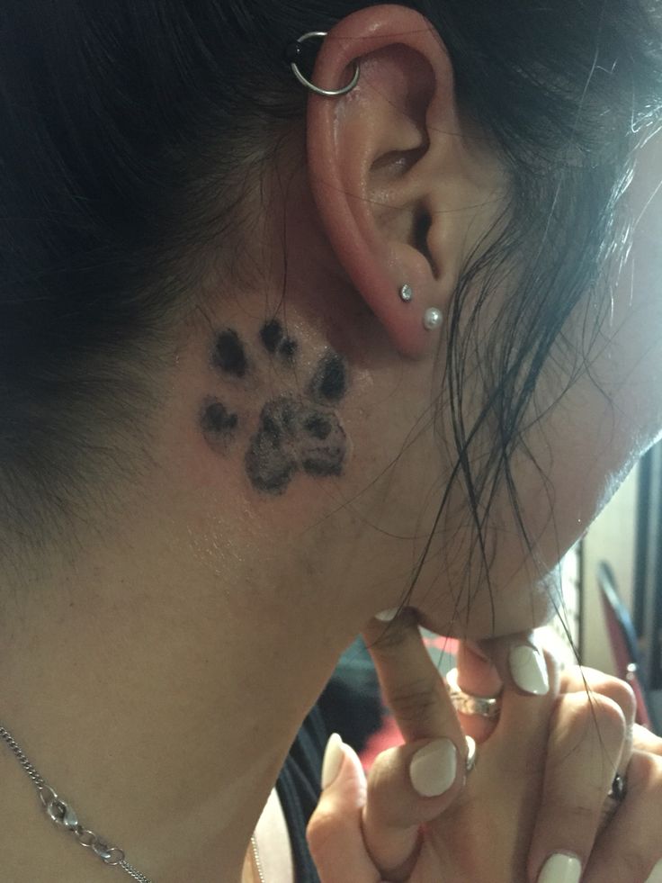 a woman with a dog paw tattoo on her left ear