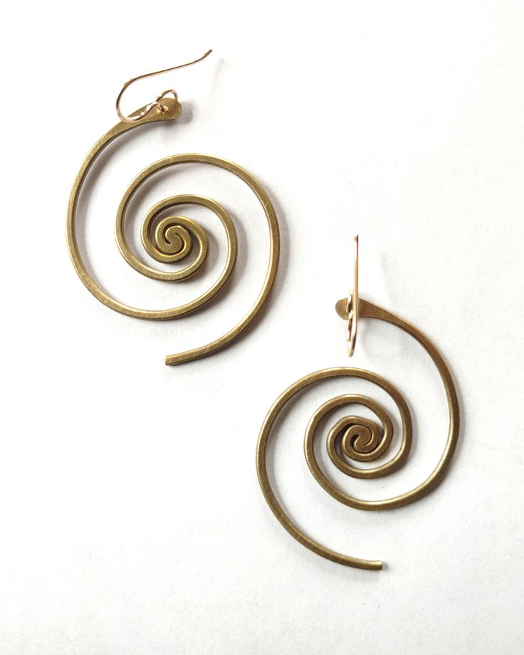 In these bronze or sterling silver plated earrings, the beauty of the universe intertwines with the artistry of the human hand. A crowd favorite, classic Lochlin Smith design. The larger sibling to our Spiral Galaxy Earrings. Length includes earwires. Earwires are 14/20 gold filled or sterling silver depending on color. Adjustable Symbolic Spiral Jewelry, Symbolic Adjustable Spiral Jewelry, Gold Sterling Silver Earrings With Artistic Design, Brass Spiral Earrings With Ear Wire, Spiral Brass Jewelry, Spiritual Bronze Earrings With Ear Wire, Unique Spiral Earrings, Spiral Brass Pierced Earrings, Artistic Nickel-free Hoop Earrings