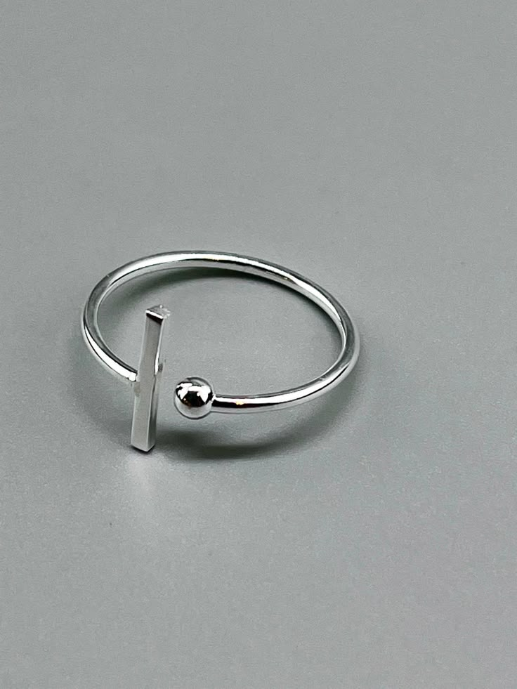 Minimalist ring in real 925 silver. This 925 silver ring with a modern and geometric look with its ball and bar is a classic of jewelry. Sober and minimalist style, this ring will quickly become an essential accessory for your outfits. Ring Size: 7 US - 54 FR They are adjustable, you can enlarge it by a size or tighten it too. Silver 925 real, it is stamped 925. Thin ring, light ring. To preserve the shine of your silver jewelry, it is recommended to: - Avoid contact with water, especially salt Silver Jewelry Minimal, Sterling Silver Minimalist Ring, Silver Rings For Women Stones, Minimalist Silver Ring For Gift, Handmade Silver Minimalist Midi Rings, Ring Stamping, Nickel-free Minimalist Sterling Silver Rings, Minimal Silver Ring, Minimalist Silver Geometric Rings